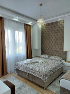 a bedroom with a large bed and a chandelier at Long beach luxury Premium apartments in Ulcinj