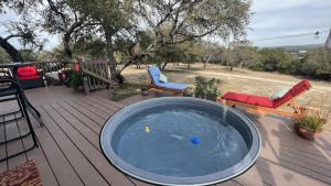 een hot tub op een terras met een bank en stoelen bij Hill Country Highland's Bluebonnet Cottage in Marble Falls