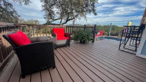 eine Terrasse mit 2 Stühlen, einem Tisch und einem Pool in der Unterkunft Hill Country Highland's Bluebonnet Cottage in Marble Falls