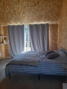 1 dormitorio con 1 cama grande y ventana en Maison de village avec cheminée et balnéothérapie, en La Ferrière-Harang