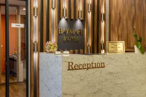 a hotel lobby with a reception counter with a sign at BayMari Suites Plus Florya in Istanbul