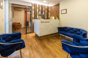 a salon with blue chairs and a reception counter at BayMari Suites Plus Florya in Istanbul