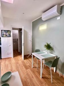 ein Wohnzimmer mit einem weißen Tisch und Stühlen in der Unterkunft La Casina Verde - Appartamento Mansardato in Livorno