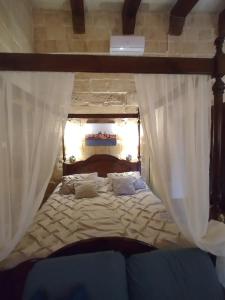 a bedroom with a bed with curtains on it at Villa Vittoria in Rabat