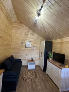 a living room with a couch and a refrigerator at Domki u Tosiek in Stegna