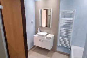 Baño blanco con lavabo y espejo en Villa des Lotophages, en Djerba