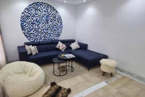 sala de estar con sofá azul y silla en Villa des Lotophages, en Djerba