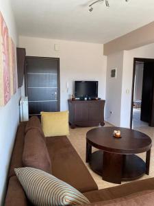 a living room with a couch and a table at Raise Mirivili Serviced Apartment in Alexandroupoli