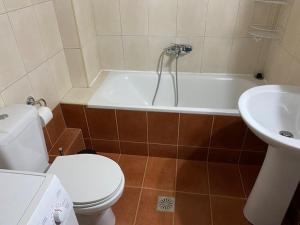 uma casa de banho com um WC, uma banheira e um lavatório. em Raise Mirivili Serviced Apartment em Alexandroúpolis
