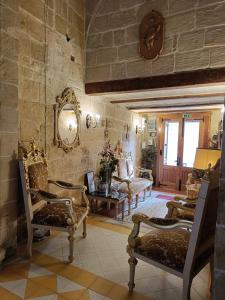 a living room with chairs and a stone wall at Villa Vittoria in Rabat