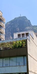 un edificio con una montaña en el fondo en Flat com serviço completo e vista Cristo, en Río de Janeiro