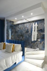 a bedroom with a bed with a blue wall at NM Luxury Suites in Pompei