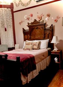 a bedroom with a large bed with a wooden headboard at Coppersmith Inn Bed And Breakfast in Galveston