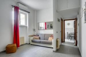 ローマにあるTIBURTINA Apartmentのリビングルーム(ソファ、赤いカーテン付)