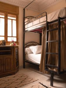 a bedroom with a bunk bed with a ladder at Santacruz Hostel in Tamraght Ouzdar