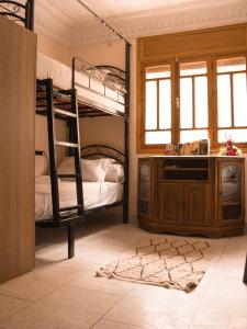 Santacruz Hostel في Tamraght Ouzdar: غرفة نوم مع سريرين بطابقين وخزانة