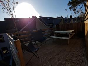 a patio with a table and chairs on a deck at Hill View in Abertillery