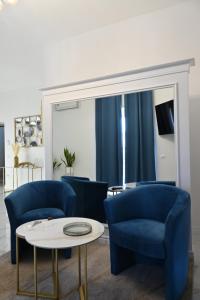 a living room with blue chairs and a table at NM Luxury Suites in Pompei