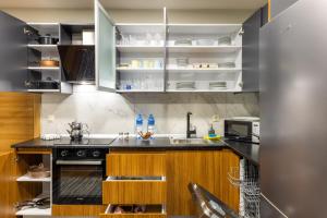 a kitchen with a black counter top and wooden cabinets at BayMari Suites Plus Florya in Istanbul