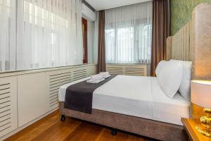 a bedroom with a large bed and windows at BayMari Suites Plus Florya in Istanbul