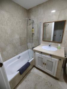 y baño con lavabo, bañera y espejo. en Apartamento 3 dormitorios Roda Golf, en Murcia