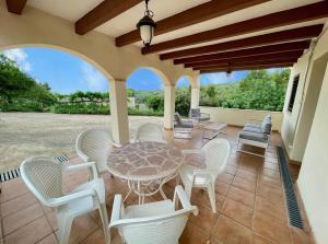 une terrasse couverte avec une table et des chaises. dans l'établissement Alojamiento Can Alegre, à El Perelló