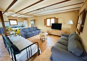 sala de estar con sofás azules y TV en Alojamiento Can Alegre, en Perelló