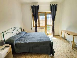 1 dormitorio con cama, escritorio y ventana en Eufonia Gemelli Apartment, en Roma