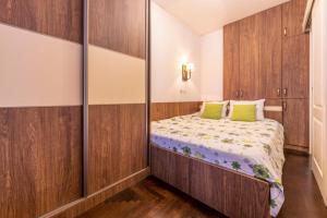 a small bedroom with a bed with green pillows at Ohrid Boutique Apartments in Ohrid