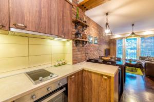 a kitchen with wooden cabinets and a brick wall at Ohrid Boutique Apartments in Ohrid