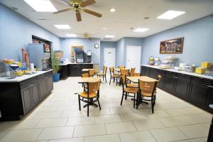 a restaurant with tables and chairs and a counter at Columbus Inn and Suites in Columbus