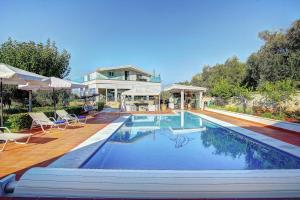 a house with a swimming pool in front of a house at The Love Villa in Kassiopi