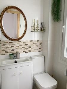 a white bathroom with a toilet and a mirror at Apartamento C/ Concepción Arenal in Ferrol