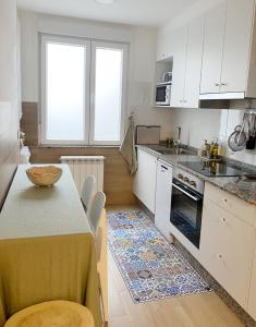 a kitchen with white cabinets and a table with chairs at Apartamento C/ Concepción Arenal in Ferrol