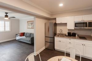 a kitchen with white cabinets and a couch in a room at French Quarter Courtyard Hotel and Suites in New Orleans