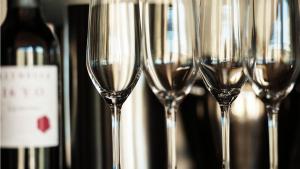 uma fila de copos de vinho em frente a garrafas de vinho em The Frames em Renmark