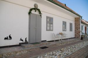 una casa bianca con una porta e un tavolo di Nótás Tücsök Vendégház ad Agyagosszergény