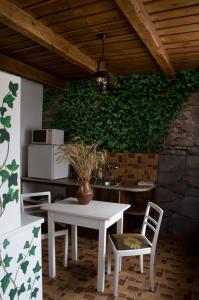 uma mesa branca e cadeiras em frente a uma parede verde em Nótás Tücsök Vendégház em Agyagosszergény
