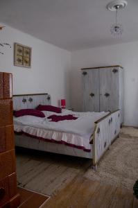 een slaapkamer met een groot bed met een houten hoofdeinde bij Nótás Tücsök Vendégház in Agyagosszergény