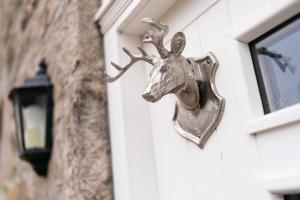 una cabeza de ciervo de bronce al lado de un edificio en Ranch House Cottage, 