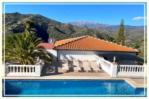 una casa con piscina di fronte a una montagna di Villa La Higuera a Sayalonga