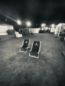 dos camas vacías sentadas en un estacionamiento por la noche en Owls Camp en Karwieńskie Błoto Drugie