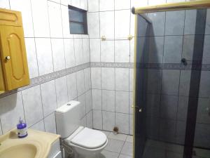 a bathroom with a toilet and a sink and a shower at Quartos Morumbi in Foz do Iguaçu