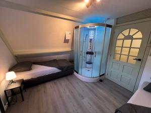 a small room with a bed and a glass shower at Rotterdam Citytrip House in Rotterdam