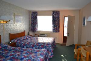 Cette chambre comprend 2 lits et une fenêtre. dans l'établissement Lighthouse Motel, à Walkerton