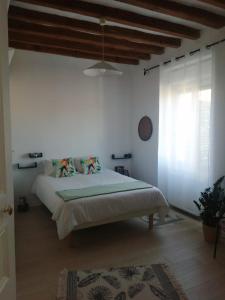 1 dormitorio con 1 cama en una habitación blanca en Maison de famille, en Saint-Mars-dʼOutillé