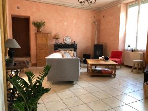 uma sala de estar com um sofá e uma mesa em Maison de famille em Saint-Mars-dʼOutillé