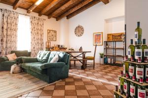 a living room with a couch and a table with wine bottles at Dimora Perla di Villa - Historical Wine Retreat near Bernina Express in Villa di Tirano