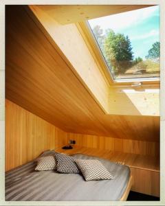 a bed in a room with a large window at NEU: Alpen-Chalet Seekarblick mit Pool in Lenggries