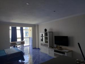 a living room with a flat screen tv and a tv stand at Apartamento Mar y Sol in Puerto de la Madera